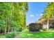 Lush backyard with a view of the house and patio, framed by mature trees and greenery at 9075 Blue Ridge Dr, Indian Land, SC 29707