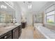 Luxurious bathroom features dual sinks, a soaking tub, and a separate walk-in shower with glass doors at 9075 Blue Ridge Dr, Indian Land, SC 29707