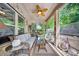 Relaxing covered porch features a brick wall, fan, and comfortable seating area, perfect for outdoor living at 9075 Blue Ridge Dr, Indian Land, SC 29707