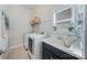 Well-equipped laundry room features a utility sink, ample counter space, and modern washer and dryer at 9075 Blue Ridge Dr, Indian Land, SC 29707