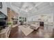 Bright living room with stone fireplace, coffered ceiling, and seamless flow to kitchen at 9075 Blue Ridge Dr, Indian Land, SC 29707