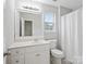 Bright bathroom with a white vanity, a large mirror, and a window with natural light at 908 Sundance Dr, Gastonia, NC 28054