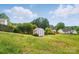 Backyard featuring a small shed with white trim and mature trees, offering a private outdoor space at 9711 Castle Terrace Ct, Charlotte, NC 28215