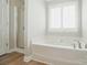 Bathroom featuring a soaking tub with a shower and a bright window at 9711 Castle Terrace Ct, Charlotte, NC 28215