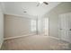 Cozy bedroom with neutral tones and a ceiling fan, featuring a door and window, creating a calming retreat at 9711 Castle Terrace Ct, Charlotte, NC 28215