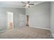 Spacious carpeted bedroom featuring a ceiling fan, neutral paint, and a double-door closet at 9711 Castle Terrace Ct, Charlotte, NC 28215