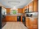 Well-lit kitchen featuring wood cabinets, black appliances, and hardwood floors at 9711 Castle Terrace Ct, Charlotte, NC 28215