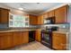 Well-lit kitchen features wooden cabinets, an oven, and granite countertops, creating a functional and inviting space at 9711 Castle Terrace Ct, Charlotte, NC 28215