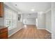Bright open-concept living room with hardwood floors and neutral walls, enhanced by natural light from a window at 9711 Castle Terrace Ct, Charlotte, NC 28215