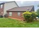A view of the house from the backyard showing brick siding, the roof, and trees surrounding the property at 102 Brandywine Ne Dr # I-1, Conover, NC 28613