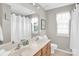 Bright bathroom featuring double sinks, a wide mirror, and a window at 1031 Butterburr Dr, Matthews, NC 28104