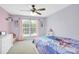 A bedroom features a window, plush carpeting, and a ceiling fan at 1031 Butterburr Dr, Matthews, NC 28104