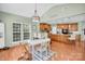 Bright dining area with a white dining set, hardwood floors, and kitchen view from the open-concept design at 1031 Butterburr Dr, Matthews, NC 28104