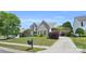 Beautifully landscaped front yard with a traditional brick home, complemented by a long driveway at 1031 Butterburr Dr, Matthews, NC 28104