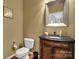 Chic half bathroom with dark wood vanity, granite countertop, and modern fixtures at 1031 Butterburr Dr, Matthews, NC 28104