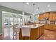 Kitchen island with granite countertop, pendant lighting, and wood cabinets at 1031 Butterburr Dr, Matthews, NC 28104