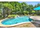In-ground pool featuring a waterfall and a seating area surrounded by greenery at 1031 Butterburr Dr, Matthews, NC 28104