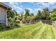 Spacious backyard with well-maintained lawn and a play structure, bordered by lush landscaping and a fence at 11109 Amur Ct, Charlotte, NC 28262