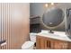 A modern bathroom featuring a wood vanity, vessel sink, decorative mirror, and stylish vertical wood paneling at 11109 Amur Ct, Charlotte, NC 28262