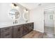 Modern bathroom featuring double sinks, quartz countertops, and sleek gray cabinetry with wood-look flooring at 11109 Amur Ct, Charlotte, NC 28262