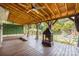 Inviting covered patio with a ceiling fan, string lights, curtains, and outdoor fireplace at 11109 Amur Ct, Charlotte, NC 28262
