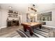 Entertain in this game room featuring a bar, custom shelving and a wooden pool table with striking light fixture at 11109 Amur Ct, Charlotte, NC 28262
