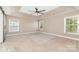 Spacious primary bedroom with tray ceiling, ceiling fan, and abundant natural light from multiple windows at 11109 Amur Ct, Charlotte, NC 28262