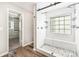 Modern bathroom with glass-enclosed shower, bench, dual shower heads, and organized closet at 11109 Amur Ct, Charlotte, NC 28262