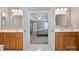 En-suite bathroom featuring dual vanities, oak cabinets, and a view through double doors to the main bedroom at 1117 Yarrow St, Matthews, NC 28104