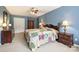 Spacious bedroom with a vibrant quilt, wooden furniture, plush carpet, and well-lit with lamps and natural light at 1117 Yarrow St, Matthews, NC 28104