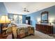 A spacious bedroom showcasing a vibrant quilt, wooden furniture, plush carpet, and sun-drenched windows at 1117 Yarrow St, Matthews, NC 28104