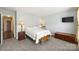 Comfortable bedroom with carpet, neutral paint, warm lamps and access to the closet and hallway at 1117 Yarrow St, Matthews, NC 28104