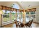 Sunlit breakfast nook with views of the pool, vaulted ceiling, large windows, and a tile-top table at 1117 Yarrow St, Matthews, NC 28104