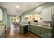 Inviting kitchen boasts green cabinetry, wood floors, and an open layout with views to the breakfast nook and living area at 1117 Yarrow St, Matthews, NC 28104