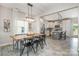 Open-concept dining area with modern lighting, wood table, and seamless flow into the kitchen at 1121 Freeman View Dr, Albemarle, NC 28001