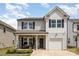 Charming two-story home with stone accents, front porch seating, and attached one car garage at 1121 Freeman View Dr, Albemarle, NC 28001