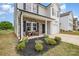 Close up of a charming front porch with stone accents, flower beds, and chair seating at 1121 Freeman View Dr, Albemarle, NC 28001