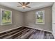 A cozy bedroom with new wood-look floors, ceiling fan, and plenty of natural light from two windows at 1154 Stringfellow Rd, Chester, SC 29706