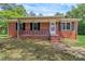 Classic brick home with black shutters, covered porch, and manicured landscaping at 1154 Stringfellow Rd, Chester, SC 29706