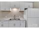 Modern kitchen with stainless sink, white cabinets and marble-look countertops at 1154 Stringfellow Rd, Chester, SC 29706