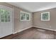 Cozy living room featuring wood-look flooring, neutral walls, and bright natural light from the window and door at 1154 Stringfellow Rd, Chester, SC 29706