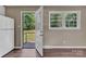 Bright living room with wood-look flooring and a door to the outside, with a small refrigerator at 1154 Stringfellow Rd, Chester, SC 29706