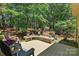 Backyard deck with outdoor seating, flowers, and forested view providing an inviting outdoor experience at 129 Willow Tree Ln, Mount Holly, NC 28120