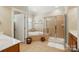 Well-lit bathroom with a soaking tub, glass-enclosed shower, and neutral tile flooring at 129 Willow Tree Ln, Mount Holly, NC 28120
