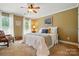 Cozy bedroom with a queen bed, windows, and a decorative chair and a wooden dresser at 129 Willow Tree Ln, Mount Holly, NC 28120