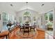 Bright dining room with wood floors, chandelier, large windows, and a door to the outside at 129 Willow Tree Ln, Mount Holly, NC 28120