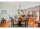 Dining room with wood floors and chandelier with the kitchen visible in the background at 129 Willow Tree Ln, Mount Holly, NC 28120