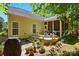 Rear exterior view showing patio, stairs to deck, and screened porch, surrounded by well-maintained landscaping at 129 Willow Tree Ln, Mount Holly, NC 28120