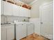 Functional laundry room with cabinets, sink, washer, and dryer at 129 Willow Tree Ln, Mount Holly, NC 28120