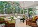 Inviting screened porch with wicker furniture, providing a serene space to enjoy the outdoors and forest view at 129 Willow Tree Ln, Mount Holly, NC 28120